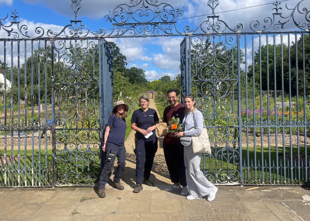 Group of 4 people in front of garden gates.