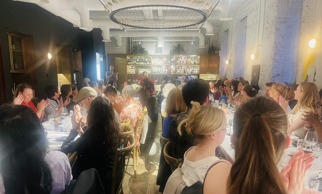 Large group sitting at tables.